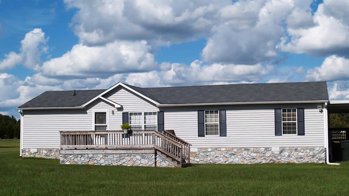 gray manufactured home with stone foundation